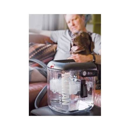 Man relaxing at home with his dog while the ICEMAN Clear3 cold therapy unit runs beside him